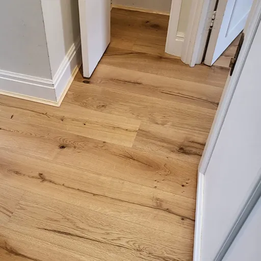 Engineered wood flooring extending across a staircase and hallway